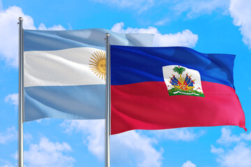 Haiti and Argentina national flag waving in the windy deep blue sky. Diplomacy and international relations concept.