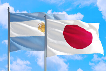 Japan and Argentina national flag waving in the windy deep blue sky. Diplomacy and international relations concept.
