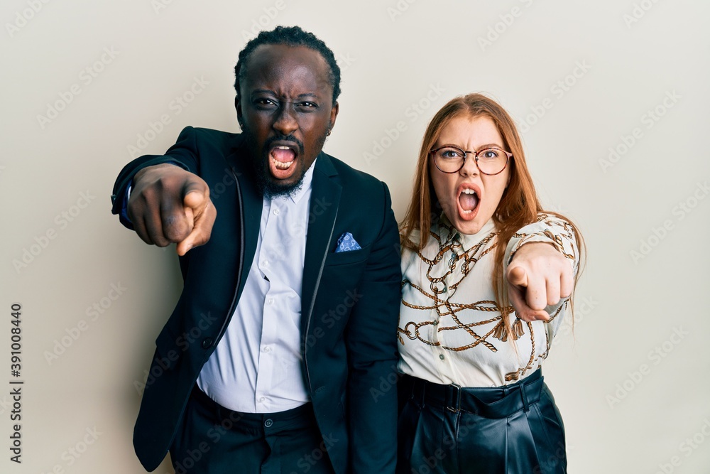 Poster Young interracial couple wearing business and elegant clothes pointing displeased and frustrated to the camera, angry and furious with you