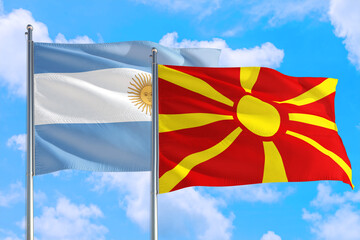 Macedonia and Argentina national flag waving in the windy deep blue sky. Diplomacy and international relations concept.