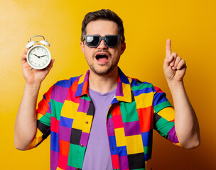 style guy in 90s shirt with alarm clock on yellow background