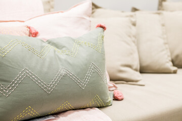 Obraz na płótnie Canvas Selection of colorful cushions on a sofa.Decorative pillows.Bedding with a trendy pillows . Copy space.Classic style of cushions and bed in pastel tone color