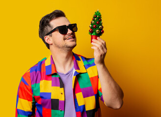style guy in 90s shirt with Christmas tree on yellow background