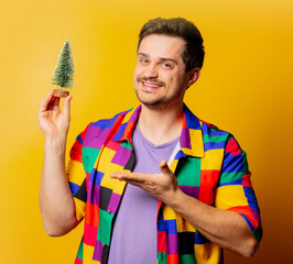 style guy in 90s shirt with Christmas tree on yellow background