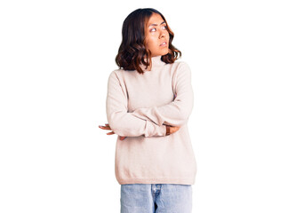 Young beautiful mixed race woman wearing winter turtleneck sweater looking to the side with arms...