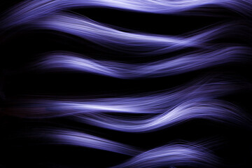 Wallpaper with bright curved lines of blue color. Background with copy space for screen or banner text. Lightpainting effect.