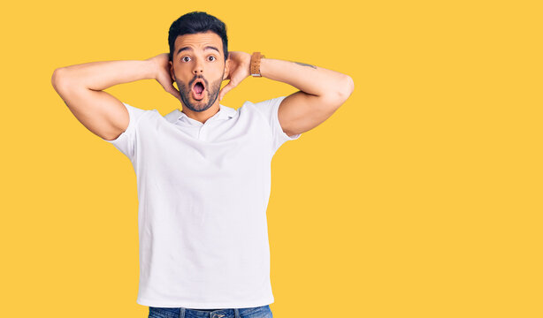 Young handsome hispanic man wearing casual clothes crazy and scared with hands on head, afraid and surprised of shock with open mouth