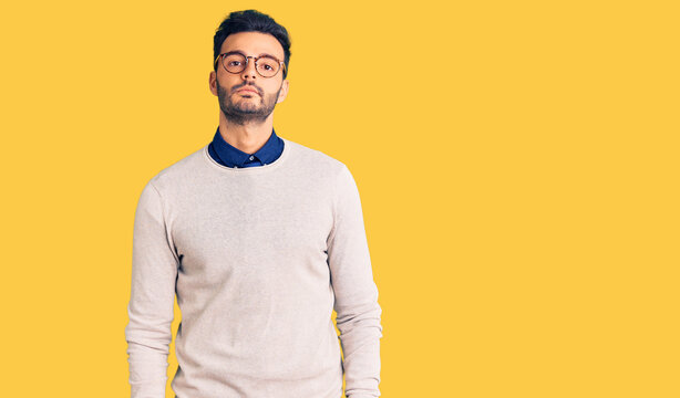 Young handsome hispanic man wearing elegant clothes and glasses relaxed with serious expression on face. simple and natural looking at the camera.