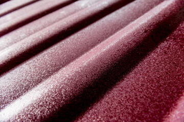 Red metallic roof tiles background with drops of water.