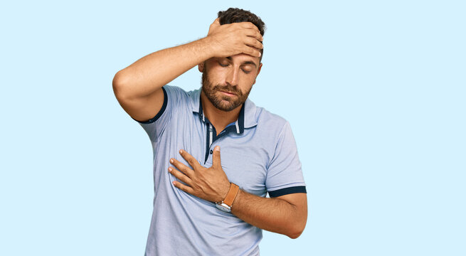 Handsome man with beard wearing casual clothes touching forehead for illness and fever, flu and cold, virus sick