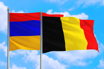 Belgium and Armenia national flag waving in the windy deep blue sky. Diplomacy and international relations concept.