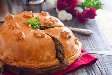 Festive Russian pie kurnik on a table with a cut piece, horizontal, copy space © Анна Журавлева