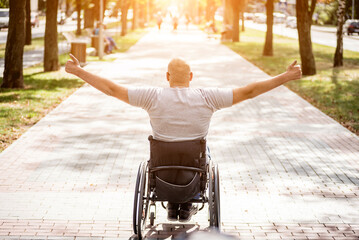 Handicapped man in wheelchair walk at the park alley