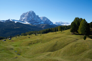 Beautiful langkofel mountain in the dolomites seen from the seceda alm with the first snow white and blue sky