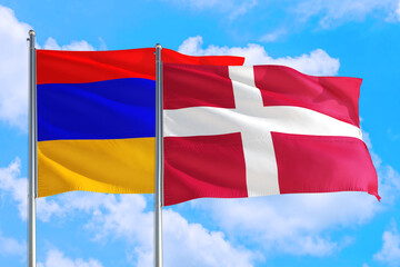 Denmark and Armenia national flag waving in the windy deep blue sky. Diplomacy and international relations concept.