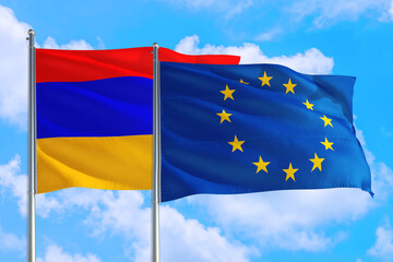 European Union and Armenia national flag waving in the windy deep blue sky. Diplomacy and international relations concept.