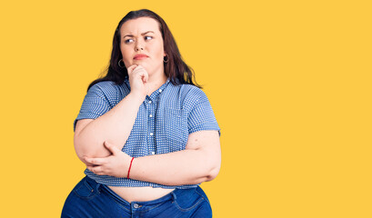Young plus size woman wearing casual clothes serious face thinking about question with hand on...
