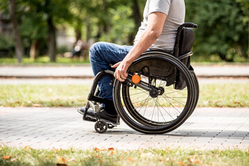 Handicapped man in wheelchair walk at the park alley