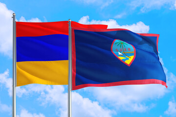 Guam and Armenia national flag waving in the windy deep blue sky. Diplomacy and international relations concept.