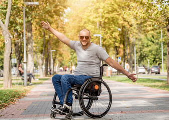 Handicapped man in wheelchair walk at the park alley
