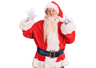 Old senior man with grey hair and long beard wearing traditional santa claus costume showing and pointing up with fingers number six while smiling confident and happy.