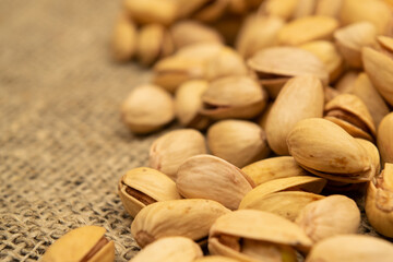 Salted pistachios lie on the burlap. Close up.
