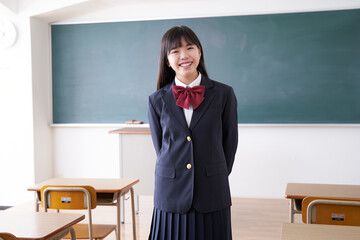 教室で笑顔で立つ日本人女子中学生