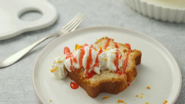 Chef decorates homemade lemon muffin with whipped cream with strawberry sauce