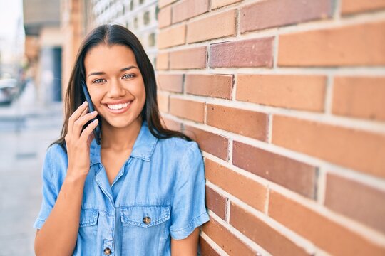 Young latin girl smiling happy talking on the smartphone at the city.