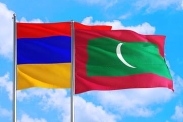 Fototapeta na wymiar Maldives and Armenia national flag waving in the windy deep blue sky. Diplomacy and international relations concept.