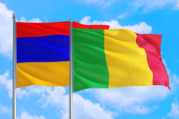 Mali and Armenia national flag waving in the windy deep blue sky. Diplomacy and international relations concept.