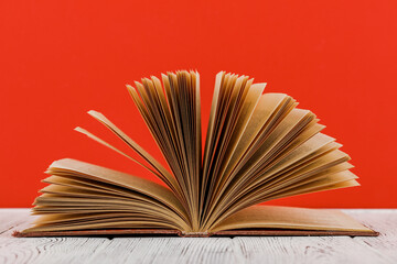 A stack of books on a white table on a red background