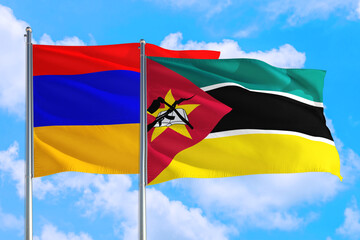 Mozambique and Armenia national flag waving in the windy deep blue sky. Diplomacy and international relations concept.