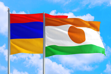 Niger and Armenia national flag waving in the windy deep blue sky. Diplomacy and international relations concept.