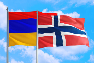 Norway and Armenia national flag waving in the windy deep blue sky. Diplomacy and international relations concept.