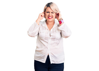 Young blonde plus size woman wearing casual shirt covering ears with fingers with annoyed expression for the noise of loud music. deaf concept.