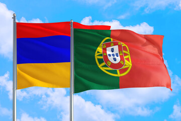 Portugal and Armenia national flag waving in the windy deep blue sky. Diplomacy and international relations concept.