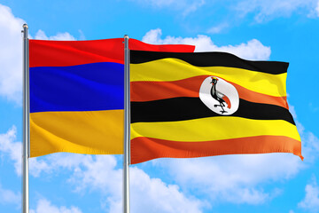 Uganda and Armenia national flag waving in the windy deep blue sky. Diplomacy and international relations concept.