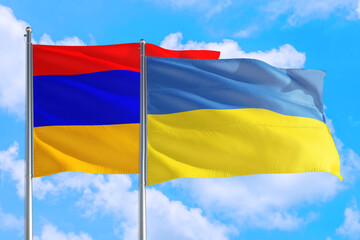 Ukraine and Armenia national flag waving in the windy deep blue sky. Diplomacy and international relations concept.