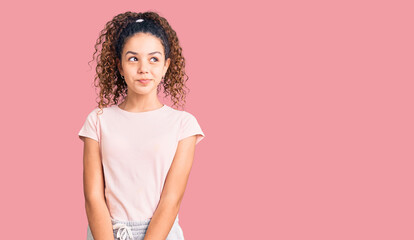 Obraz premium Beautiful kid girl with curly hair wearing casual clothes smiling looking to the side and staring away thinking.