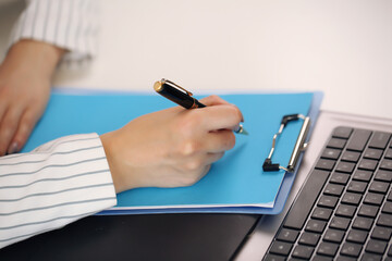 Beautiful brunette young business woman in the office showing folder copy space