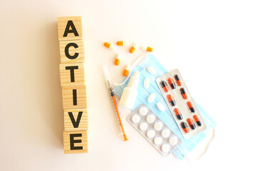 The word ACTIVE is made of wooden cubes on a white background. Medical concept.