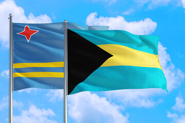 Bahamas and Aruba national flag waving in the windy deep blue sky. Diplomacy and international relations concept.