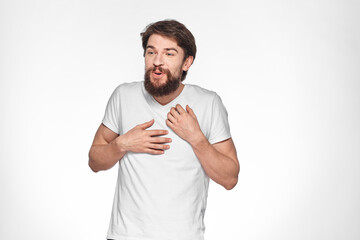 Bearded man in white t-shirt gesture with hands emotions light background