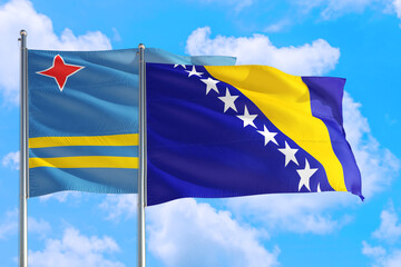 Bosnia Herzegovina and Aruba national flag waving in the windy deep blue sky. Diplomacy and international relations concept.