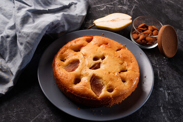 Homemade pear cake, on a black metal background.