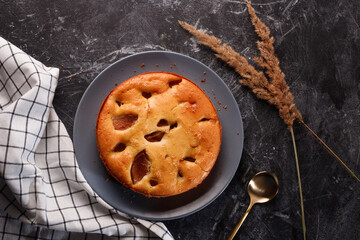 Homemade pear cake, on a black metal background.