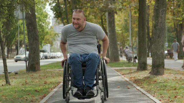 Handicapped man in wheelchair walk at the park alley