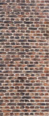 
An old brick wall made of bricks of an unusual color.