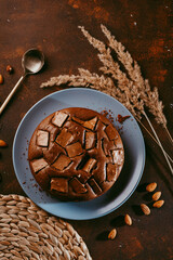 Chocolate cake with chocolate pieces on a brown background